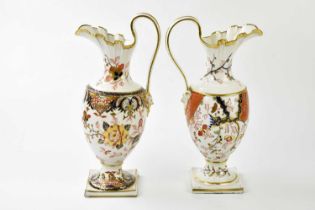 DERBY; two 19th century ewers each with Imari decoration with mask head terminals, height 33cm.