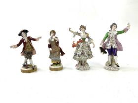 A pair of 20th century Continental porcelain figures of a gentleman and lady wearing traditional