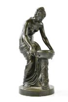 A late 19th century bronze figure representing a scantily clad classical figure kneeling lifting a
