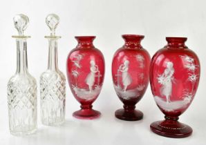 Three Mary Gregory style Victorian cranberry glass vases with opaque decoration of girl in landscape