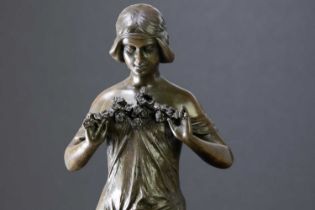A reproduction bronze figure of an Art Nouveau style maiden with a band to her hair and a floral