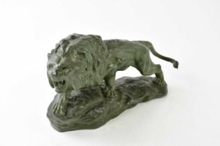 T CARTIER; a painted bronzed spelter figure of a lion upon rock, signed to base, height 17cm.