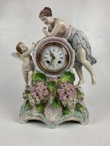 A late 19th century German porcelain figural mantel clock representing a maiden leaning towards a