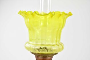 A Victorian oil lamp, the vaseline and clear glass shade with wavy rim and etched floral
