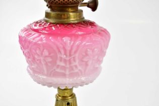 A late Victorian oil lamp, the cranberry and clear glass shade with etched decoration and wavy rim