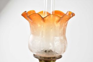 A late Victorian oil lamp, the orange tinted and clear glass shade with wavy rim and etched