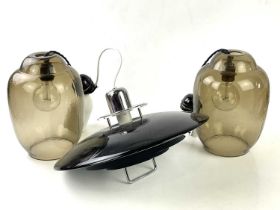 A pair of smoked art glass light shades, 31cm, together with a larger circular black painted light