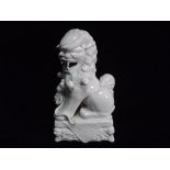 Chinese Blanc De Chine Dehua Style Porcelain figure of a Temple Lion with Brocade Ball. Standing