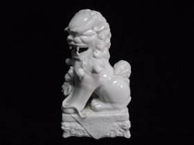 Chinese Blanc De Chine Dehua Style Porcelain figure of a Temple Lion with Brocade Ball. Standing