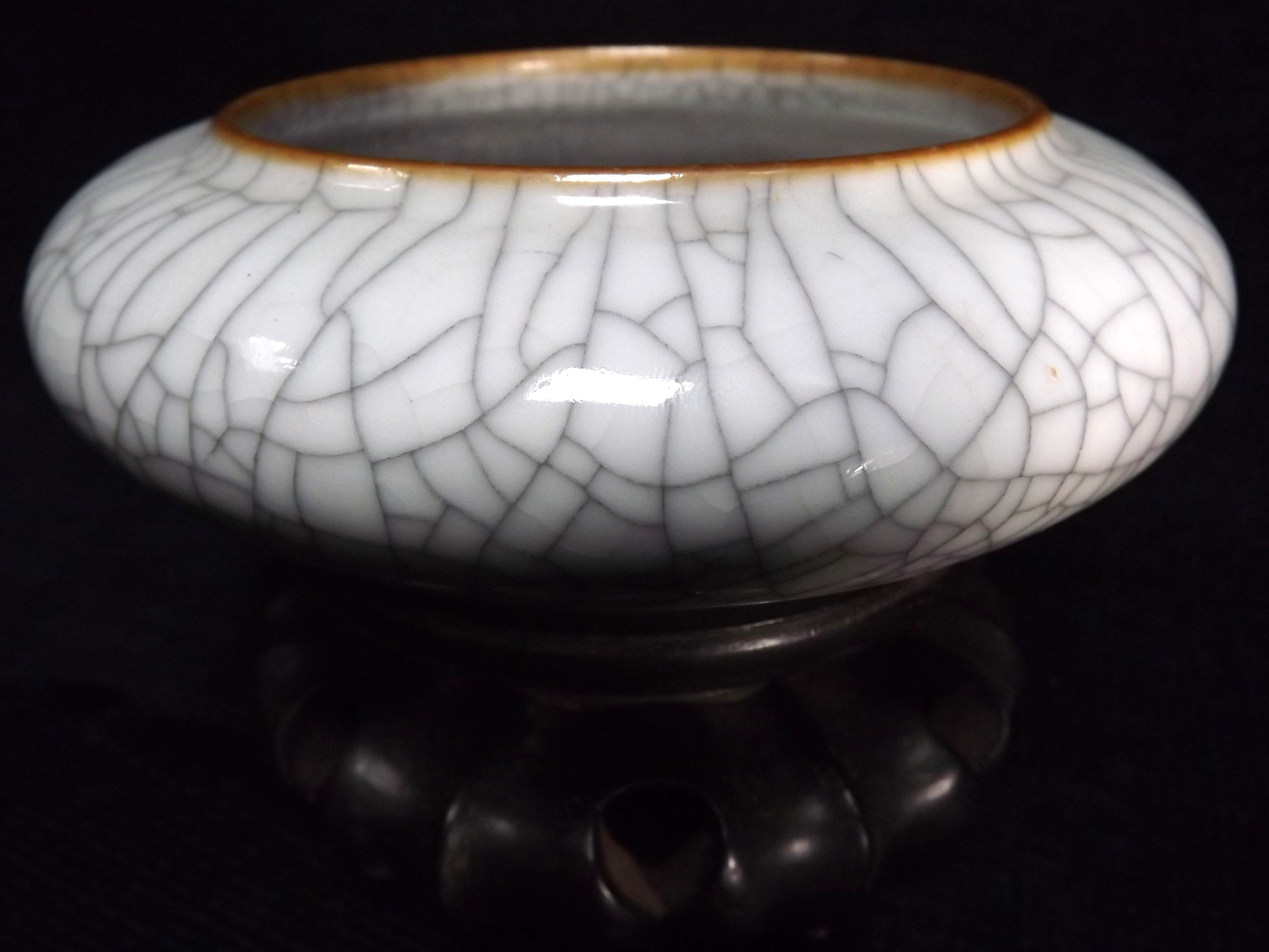 Chinese Ge Gu style shallow ceramic Dish on wooden stand. Typical crackle glaze pottery with iron