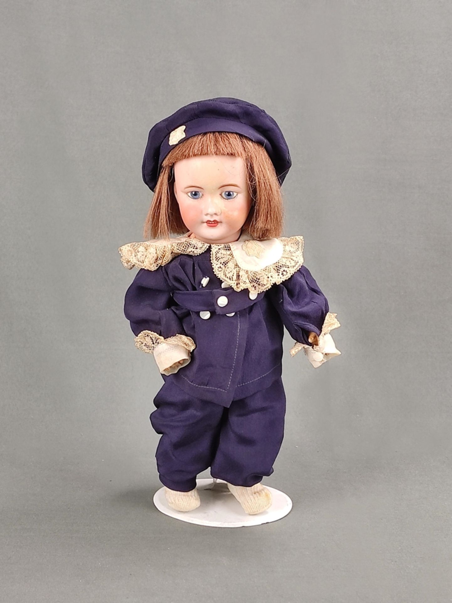 Doll, marked Unis France, porcelain head with blue glass eyes and human hair wig, length doll 31cm,