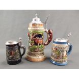 Three beer jugs, stoneware, each with hinged pewter lid with thumb latch and various surrounding fi