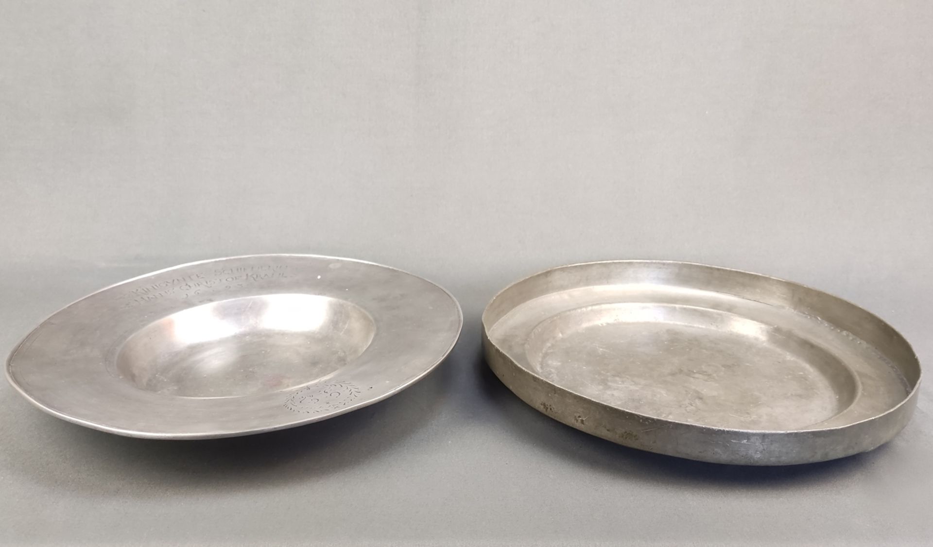 Two antique pewter plates, consisting of: Plate with wide flag and deep mirror, engraved band on th