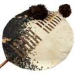 A SWAZI HIDE SHIELD, the circular cattle hide shield with rectangular slit decoration to the front