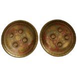 A NEAR PAIR OF BENARES SHIELDS, the 35cm diameter brass bodies with turned rims, four dome brass