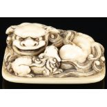 Japan 19th century, ivory Tomochika netsuke shishi with boy, signed, Edo period,