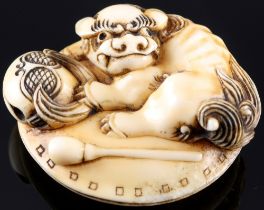 Japan 19th century, ivory Manju-Netsuke Shishi with temple bell, Meiji period,