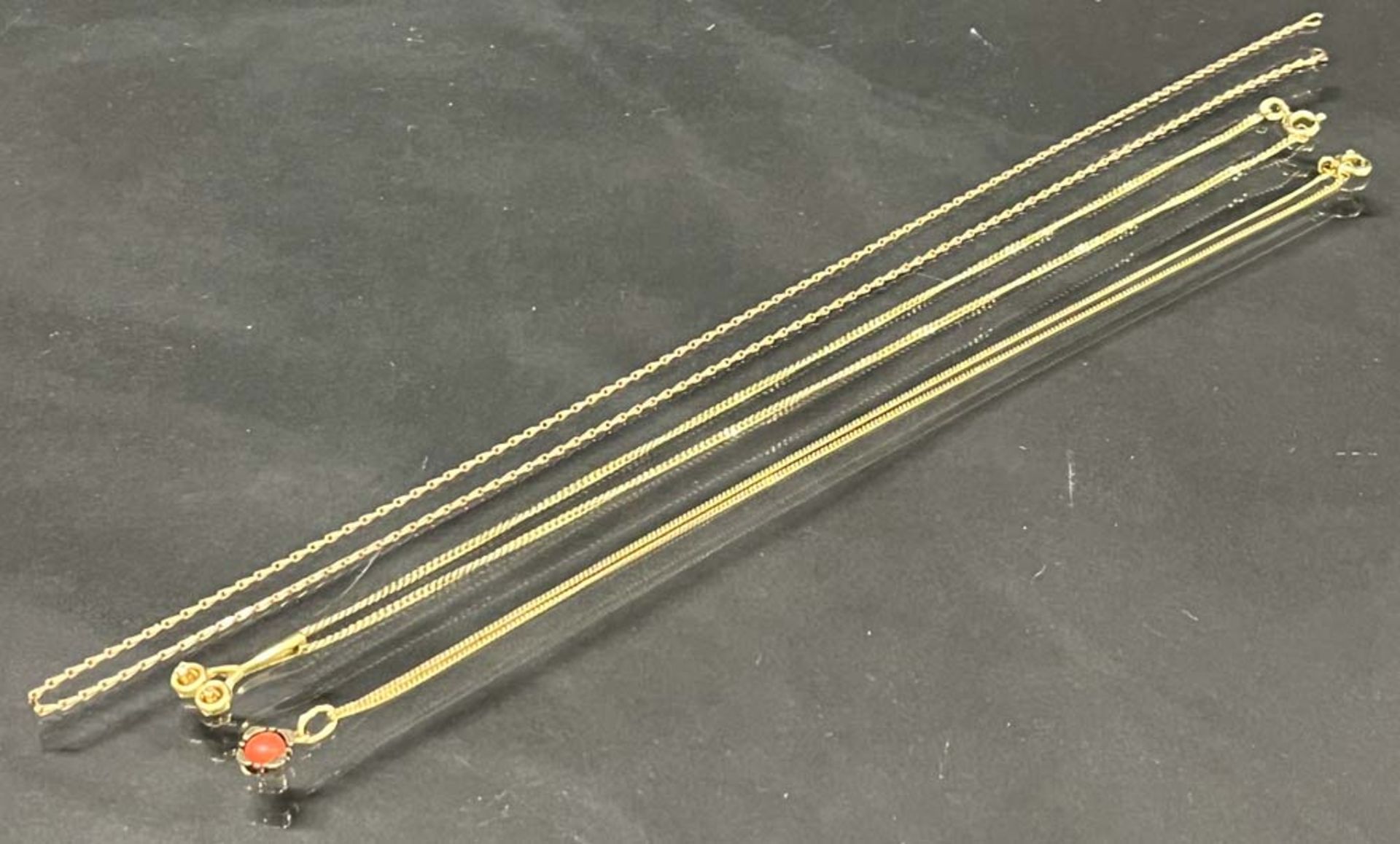 Drei Ketten. 8 ct Gold, ca. 8 g, dazu zwei Anhänger, besetzt mit Brillant, ca. 0,02 ct, und Koralle.