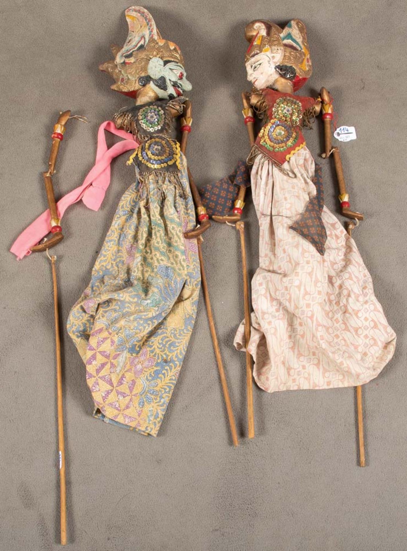Zwei Wayang-Puppen. Indonesien. Holz, geschnitzt, bemalt, bunte Stoffkleider, H=je 90 cm.