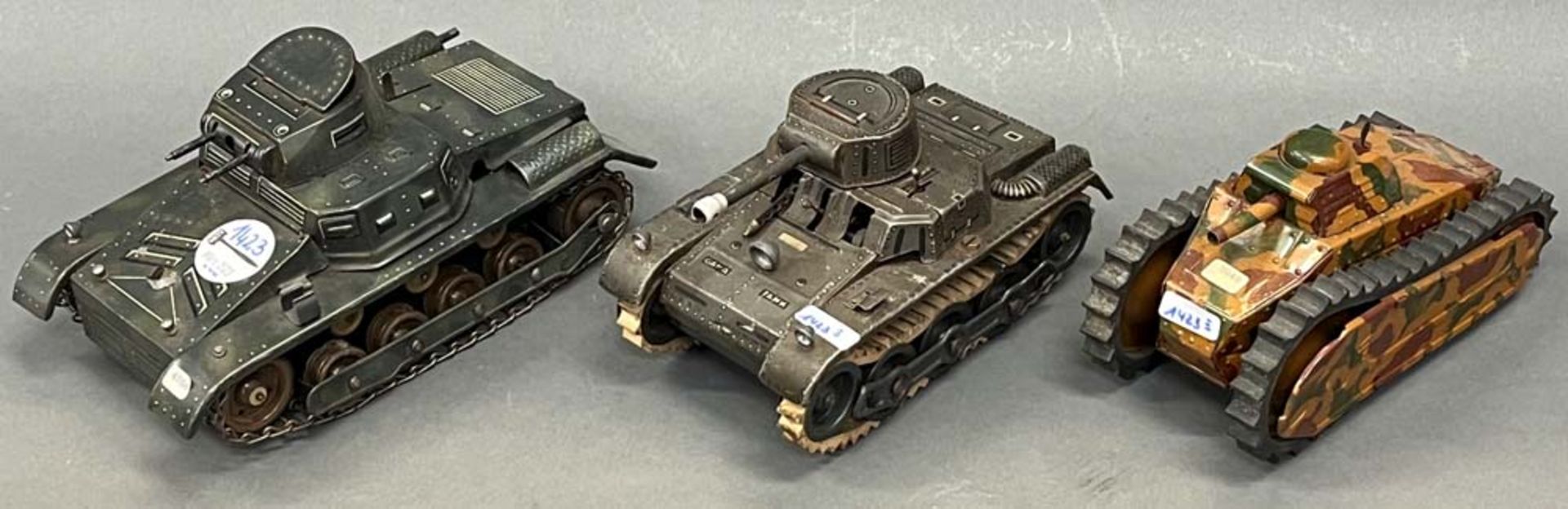 Drei verschiedene Panzer. Deutsch 20. Jh. Blech, bunt bemalt, H=10 bis 12 cm.