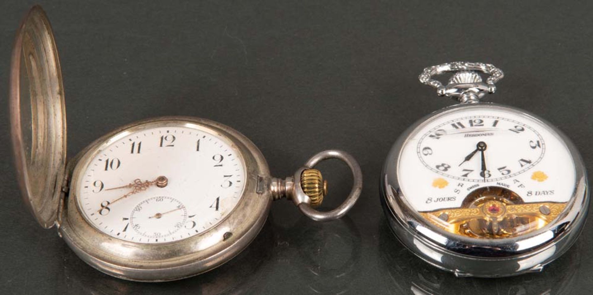 Zwei Taschenuhren. IWC / Hebdomas. Silber bzw. Metall, IWC auf Werk gemarkt. (Funktion ungeprüft)