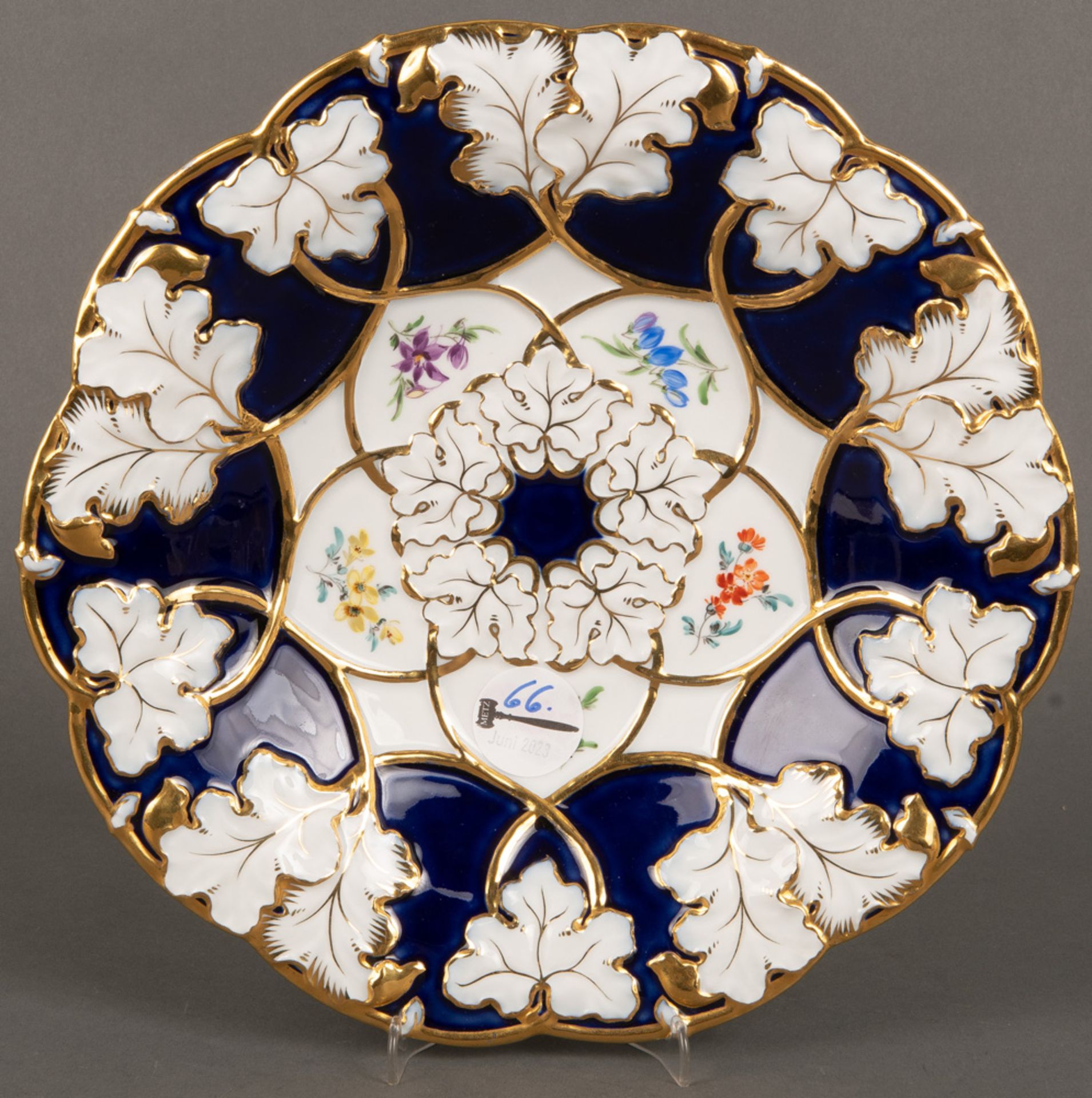 Runde Prunkplatte. Meissen 1924-34. Porzellan, kobaltblauer Fond, gold gesäumt, Freiräume bunt