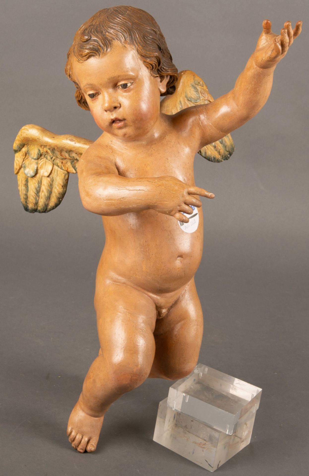 Putto. Süddeutsch 18./19. Jh. Holz, geschnitzt, auf Kreidegrund farbig gefasst, H=44 cm, B=25 cm.