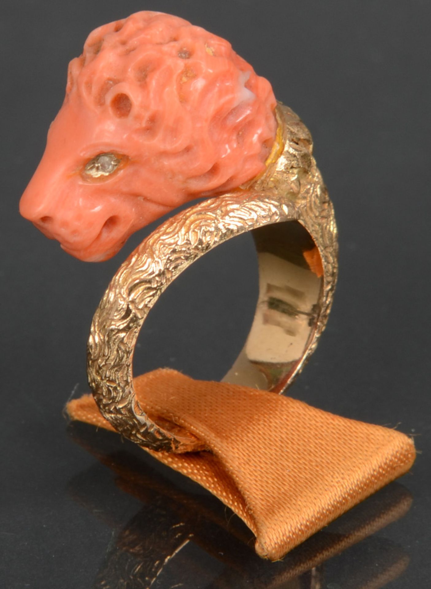 Ring. 18 ct Gold, besetzt mit Koralle, geschnitzt als Löwenkopf, ca. 14 g. (Ringgröße 51)