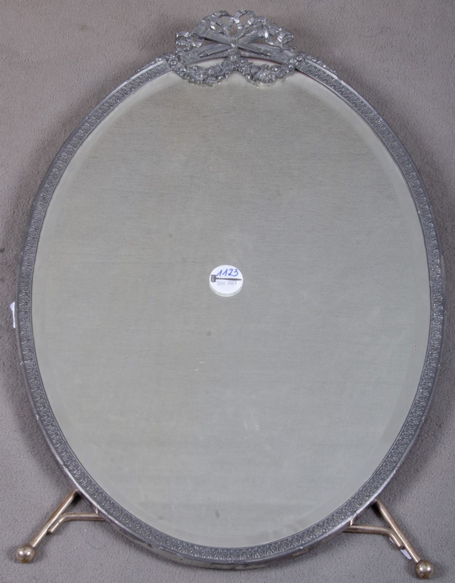 Ovaler Tischspiegel. Deutsch 19. Jh. Versilbert, mit Reliefdekor und Perlfries, 58,5 x 40 cm. **