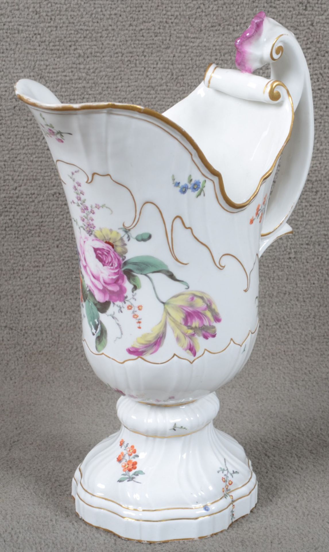 Helmkanne. Höchst um 1765. Porzellan, bunt bemalt mit Floraldekor, Goldrand. Am Boden purpurne