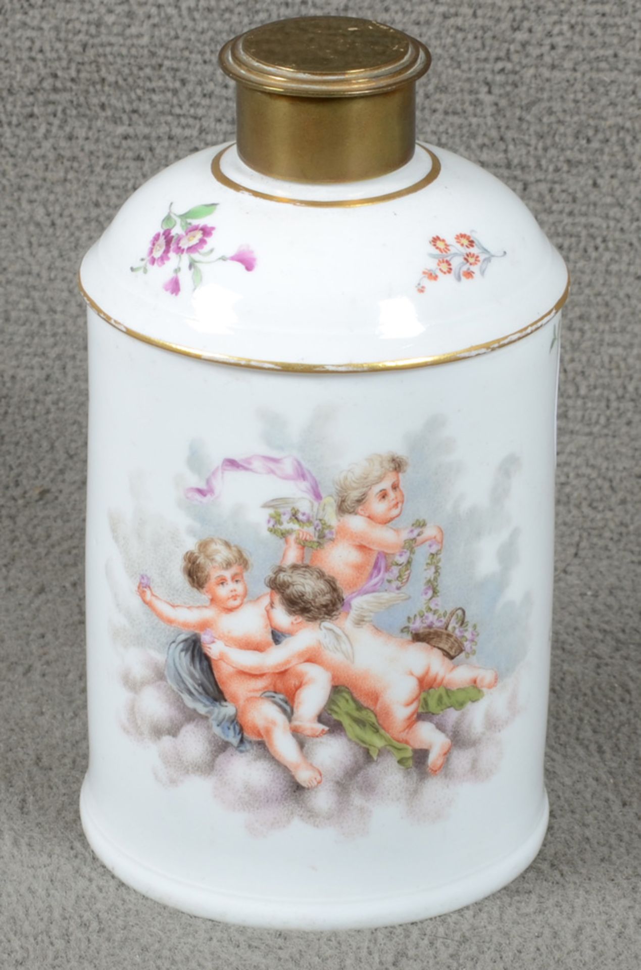 Teedose. Höchst um 1770. Porzellan, bunt bemalt mit fliegenden Putten und Floraldekor. Am Boden