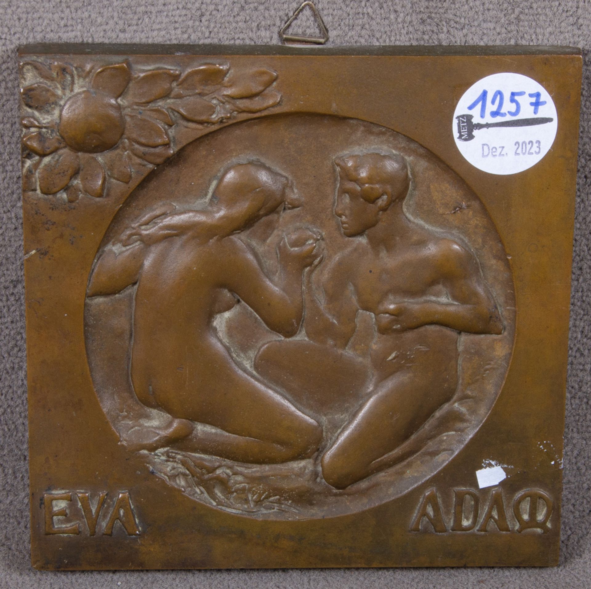 Wandkachel „Eva Adam“. Deutsch um 1900. Bronze, reliefiert und beschriftet, 16,5 x 16,5 cm.