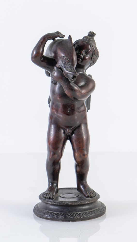 Scultura in bronzo raffigurante cherubino con delfino. Francia, inizio del XIX secolo. Cm 26x10,5x10