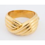 Bracciale rigido in oro giallo 18K, realizzato con motivo a nastro. Peso complessivo 101,8 grammi.