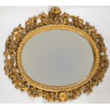 Specchiera a cartoccio ovale in legno intagliato e dorato. Toscana, XIX secolo. Cornice caratterizza
