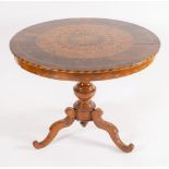 Tavolo tondo lastronato in legno di noce, acero e ciliegio, con motivi geometrici concentrici. Soste