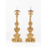 Coppia di candelabri in legno intagliato e dorato. Italia, XVIII secolo. Ciascuno di cm 55x16,5x10.(