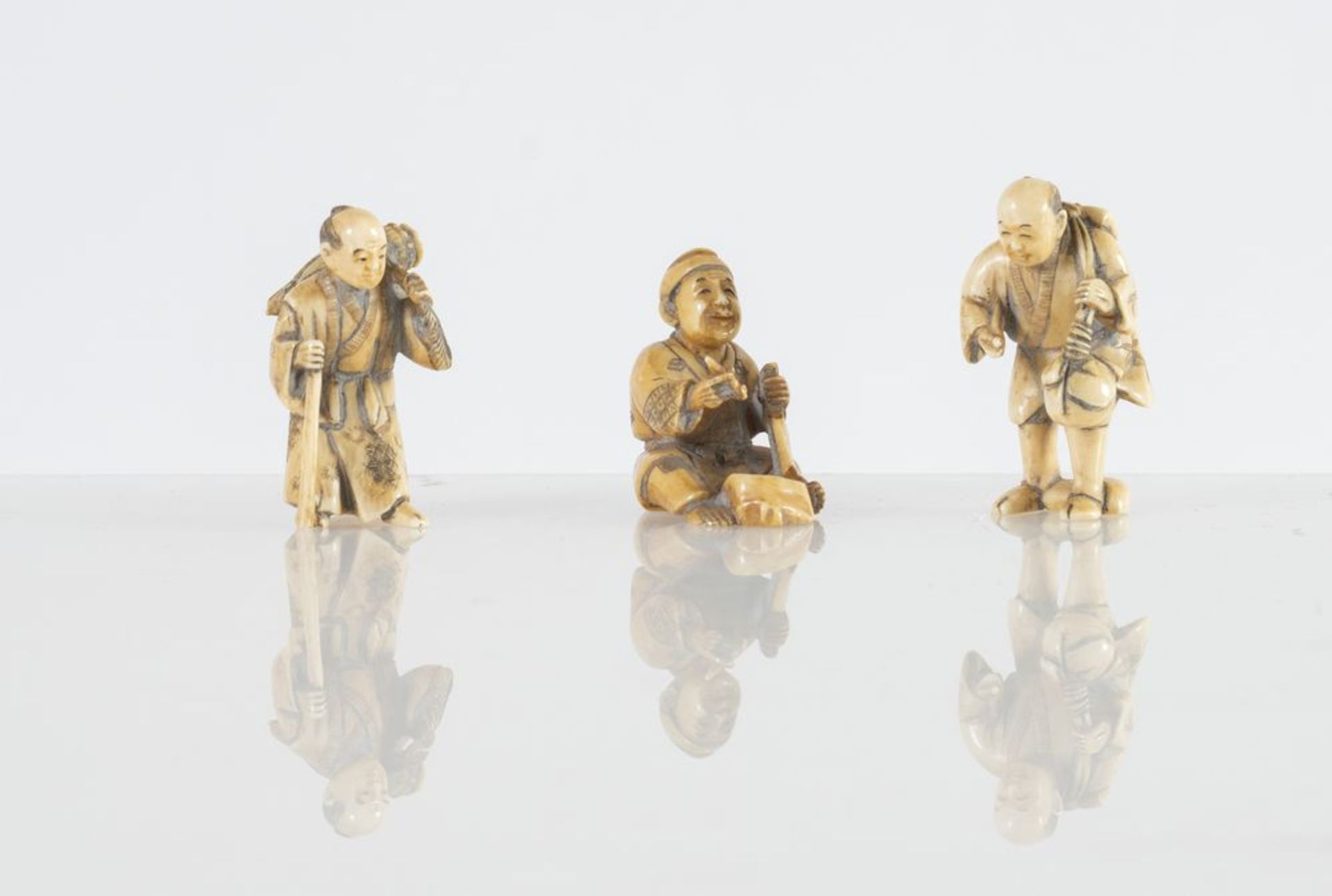 Lotto composto da tre netsuke in avorio, raffiguranti tre lavoratori. Giappone, XIX secolo. Lotto ac