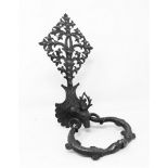 Wrought and chiseled iron door knocker carved with a stag's head, holding the ring formed by two