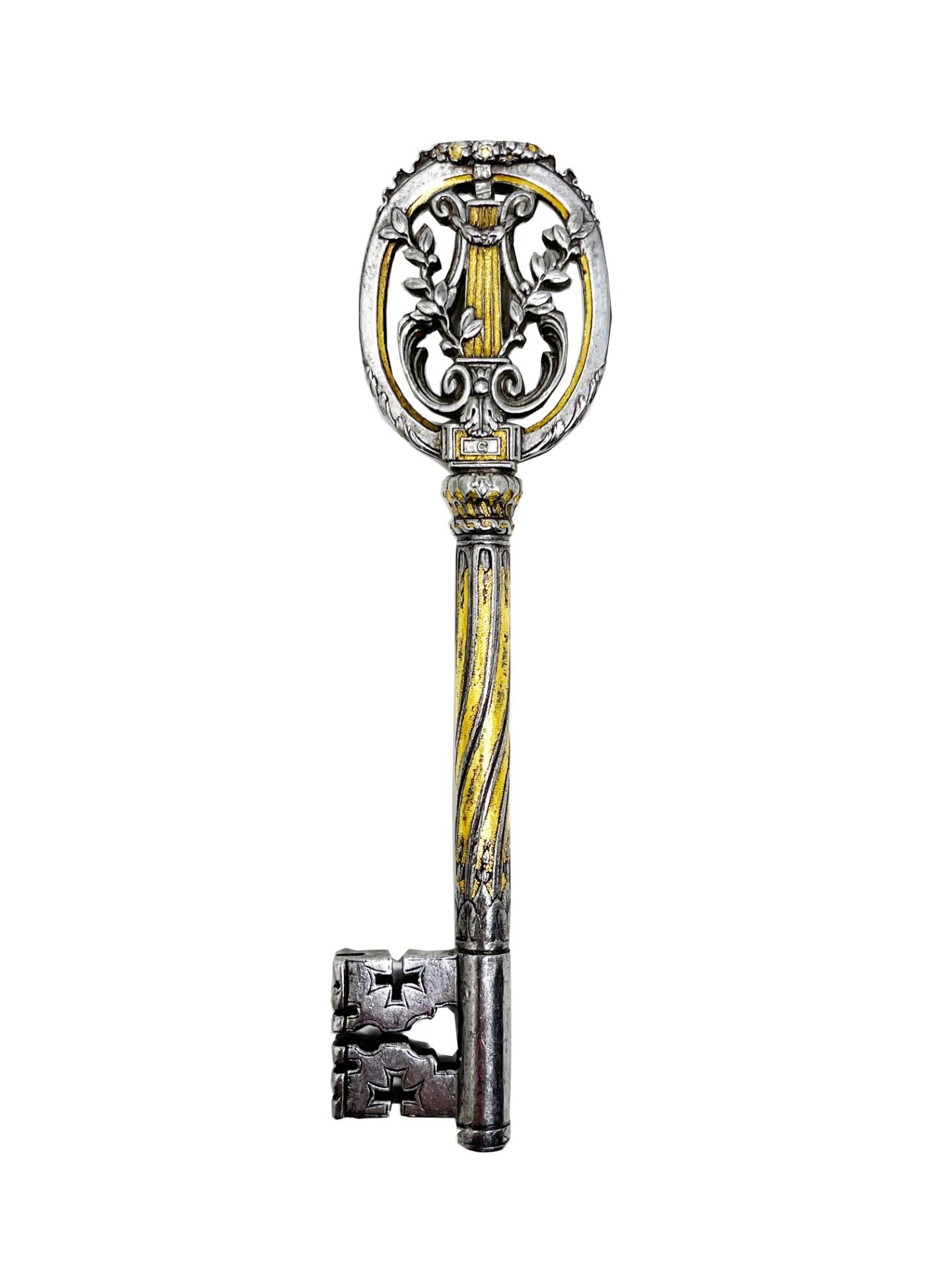 Iron key nielloed in gold. Oval ring topped by a wreath of flowers and containing a lyre and two