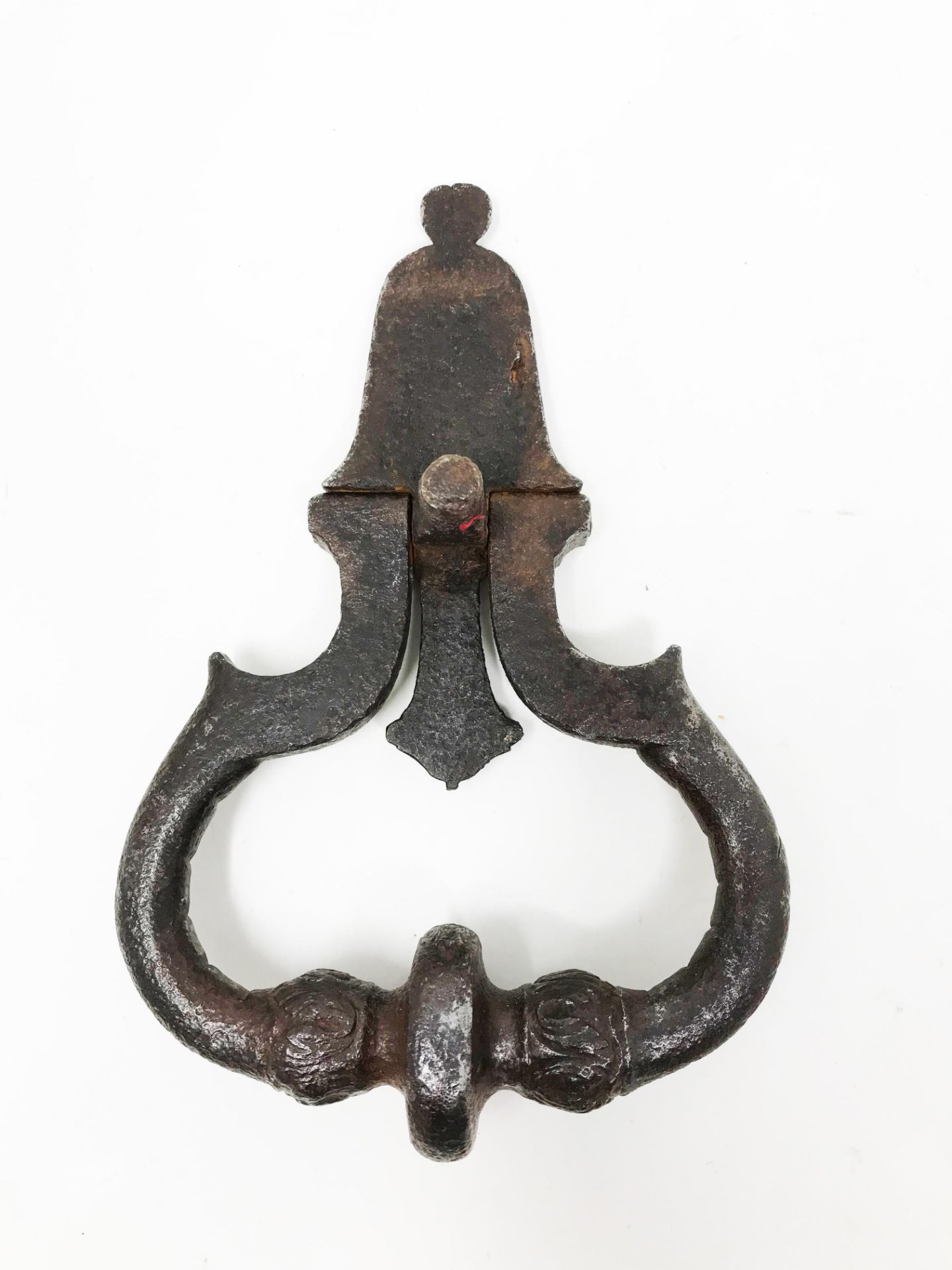 Wrought and carved iron knocker with two masks. The bulbs of the twisted ring engraved with