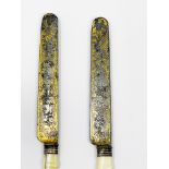 Two table knives for a couple. Bone handles with engraved and gilded blades showing on the obverse