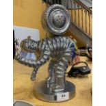A CHROME EFFECT MODEL OF A MICHELIN MAN WITH TYRE