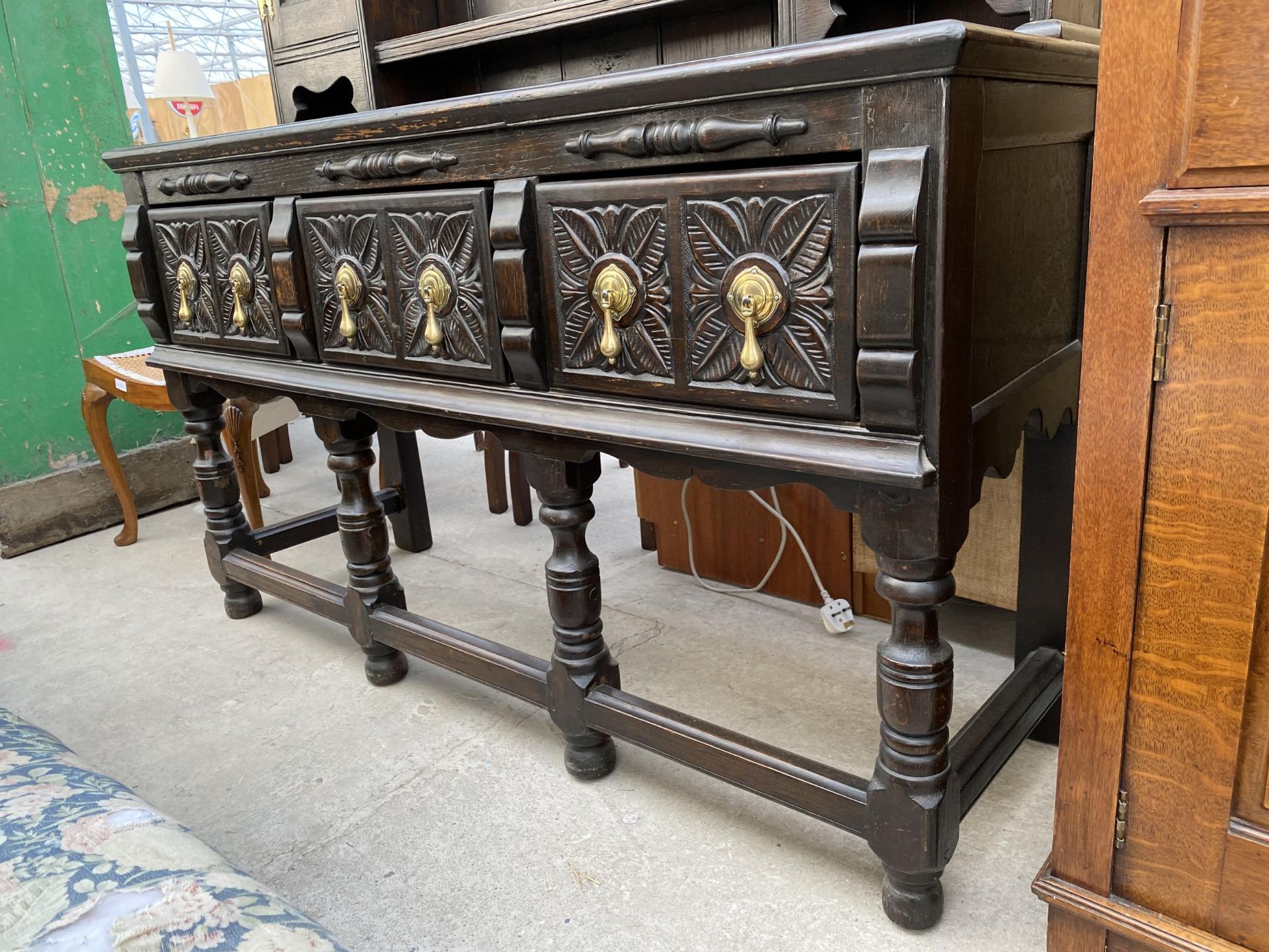 AN OAK JACOBEAN STYLE DRESSER WITH PLATE RACK ENCLOSING CUPBOARDS, THREE CARVED DRAWERS TO BASE ON - Image 3 of 6