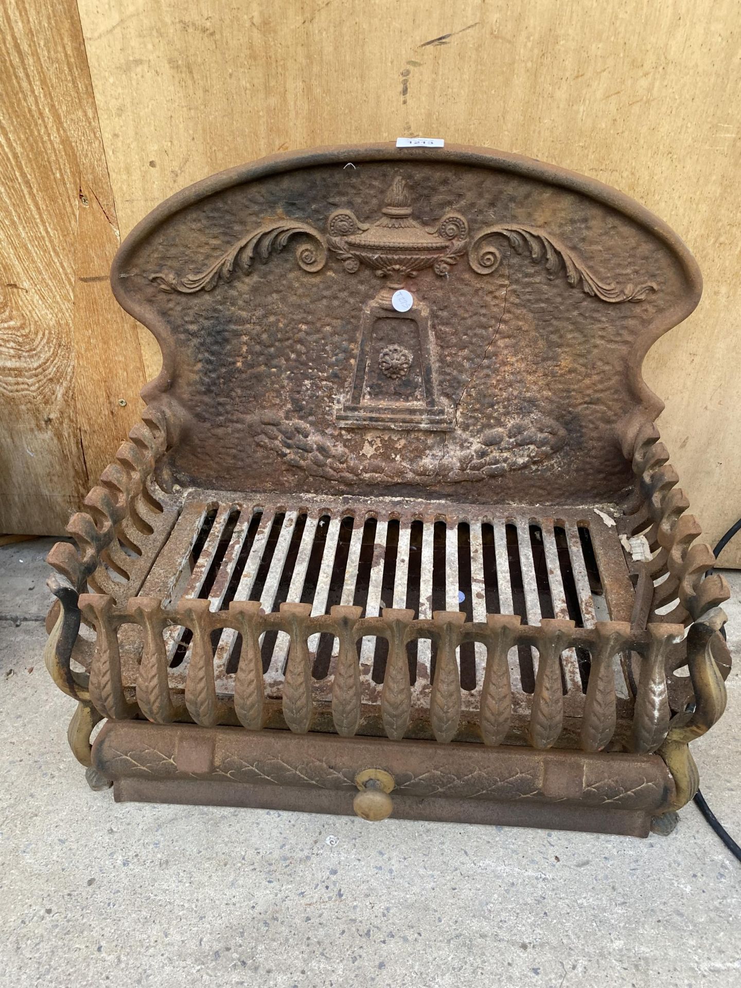 A VINTAGE CAST IRON FIRE GRATE WITH DECORATIVE CAST IRON BACK