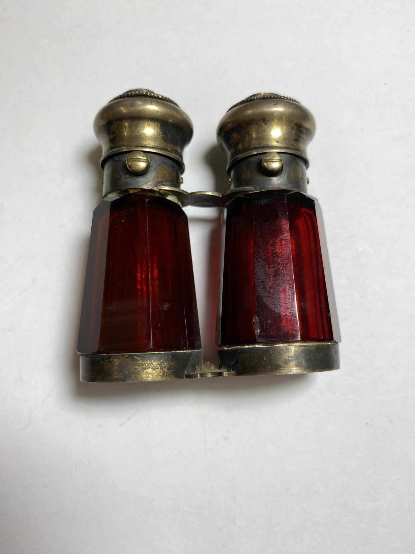 A VINTAGE CRANBERRY GLASS AND METAL DOUBLE PERFUME BOTTLE MODELLED IN THE FORM OF OPERA GLASSES