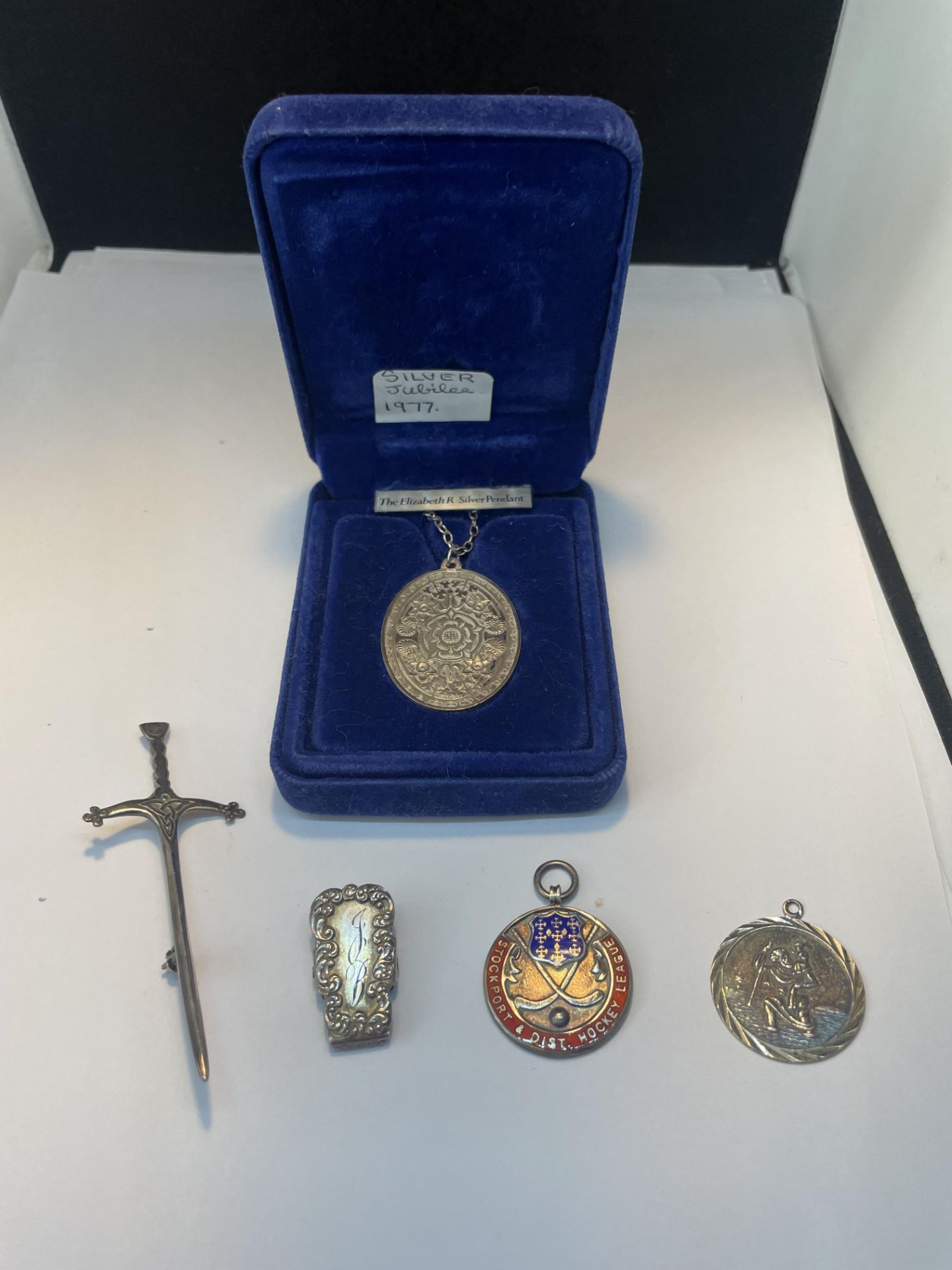 FIVE MARKED SILVER ITEMS TO INCLUDE A DAGGER BROOCH, MEDAL, ST CHRISTOPHER, CLIP AND A BOXED