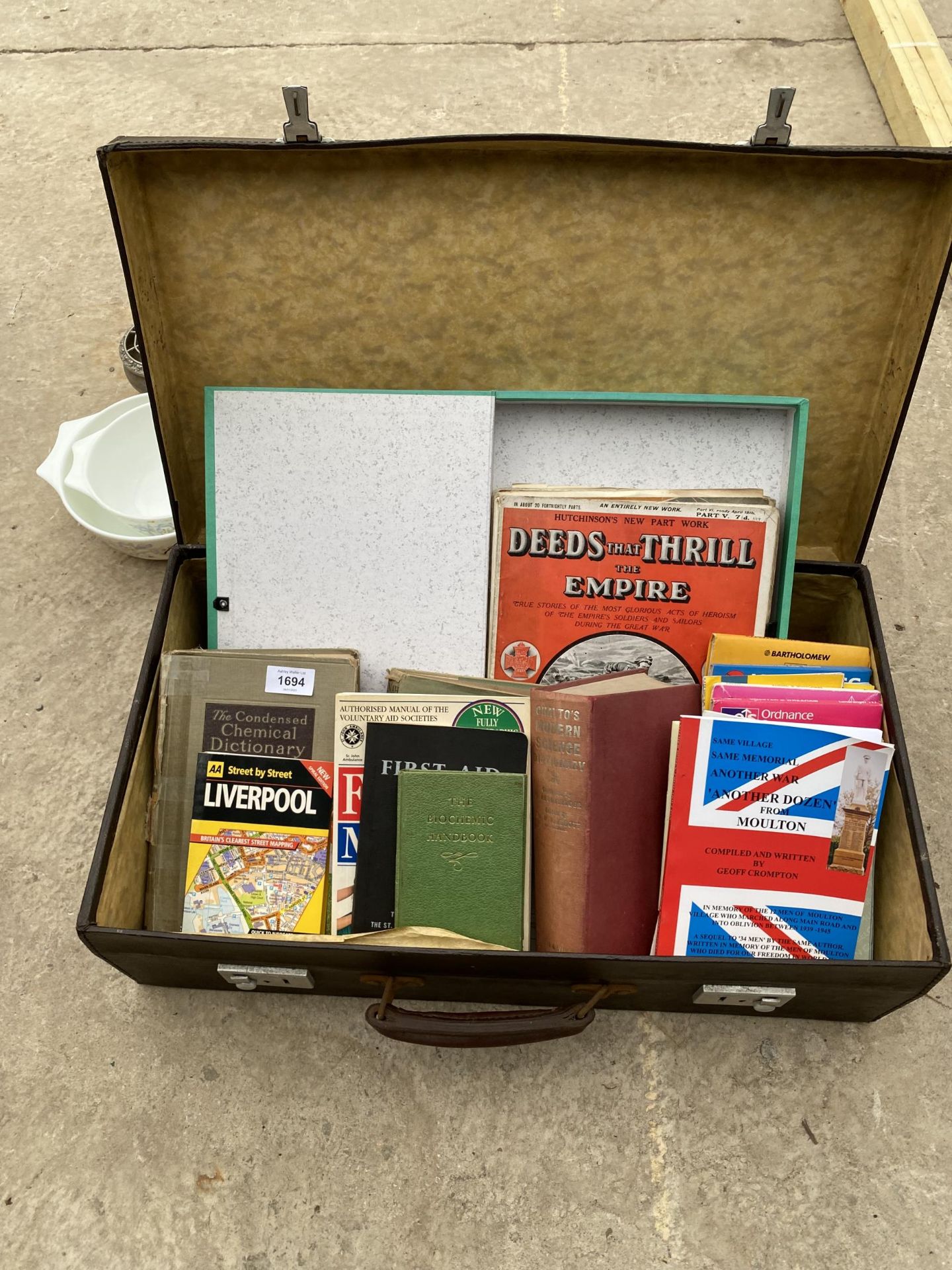A SUITCASE CONTAINING AN ASSORTMENT OF BOOKS