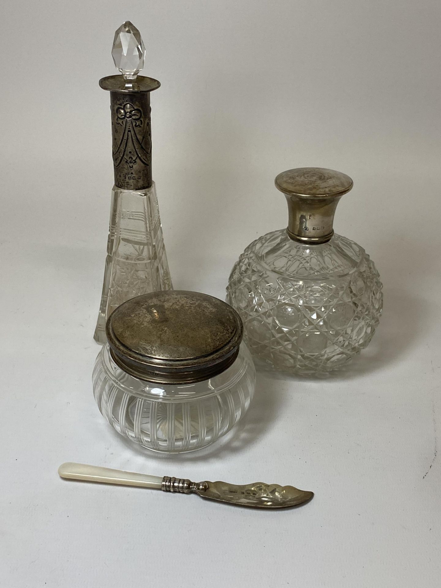 FOUR HALLMARKED SILVER ITEMS - THREE GLASS & SILVER TOPPED ITEMS AND A MOTHER OF PEARL HANDLED KNIFE