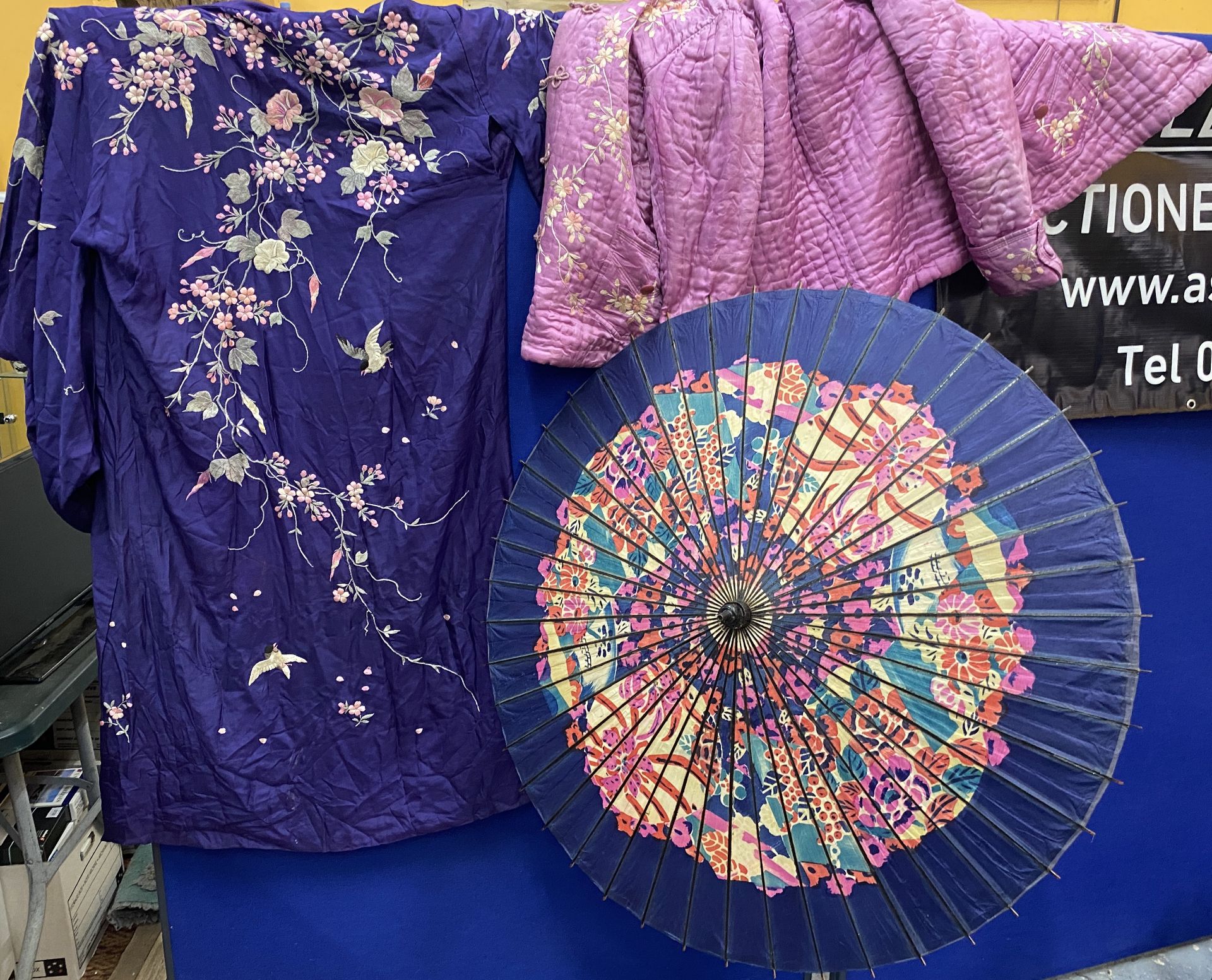 THREE ITEMS - TWO FLORAL EMBROIDERED SILK GOWNS TOGETHER WITH A VINTAGE ORIENTAL PARASOL